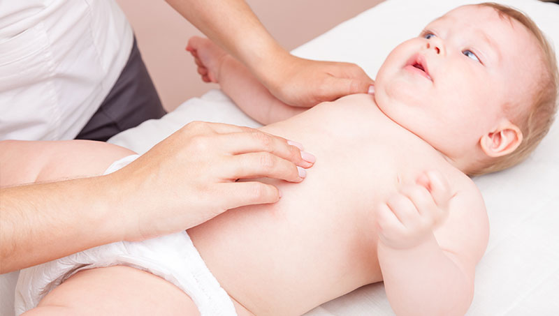 Infant being treated for colic with chiropractic care