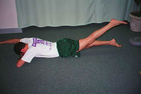 Dr. Ezgur performing Prone Glute Squeeze with Cross Crawl exersise